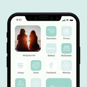 May include: A smartphone screen displaying a variety of app icons, including Doordash, Photos, BeReal, McDonalds, Prime Video, Tasks, Facebook, Meetup, and Widgetsmith. The icons are arranged in a grid pattern on a light blue background.