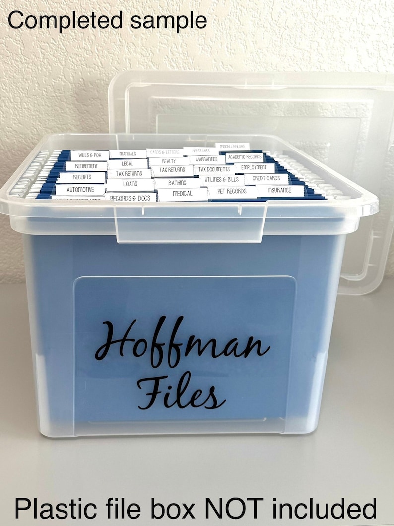 Puede incluir: Una caja de archivo de pl&aacute;stico transparente con un interior azul y una etiqueta que dice "Hoffman Files". La caja est&aacute; llena de carpetas colgantes etiquetadas con varias categor&iacute;as, que incluyen "Wills & POA", "Retirement", "Receipts", "Automotives", "Manuals", "Legal", "Tax Returns", "Loans", "Records & Docs", "Ads & Letters", "Realty", "Tax Returns", "Banking", "Medical", "Warranties", "Tax Documents", "Utilities & Bills", "Pet Records", "Academic Records", "Employment", "Credit Cards" e "Insurance".