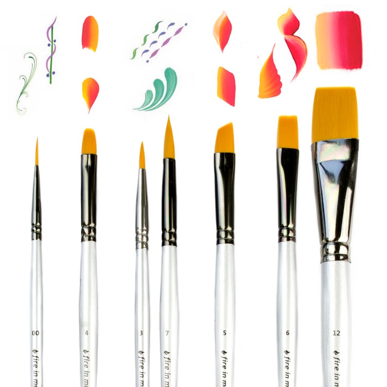 May include: A set of seven paint brushes with silver handles and yellow synthetic bristles, labeled with sizes 00, 4, 3, 7, 5, 6, and 12. Each handle features the text "fire in me". Above the brushes are various painted strokes in orange, pink, green, and purple.