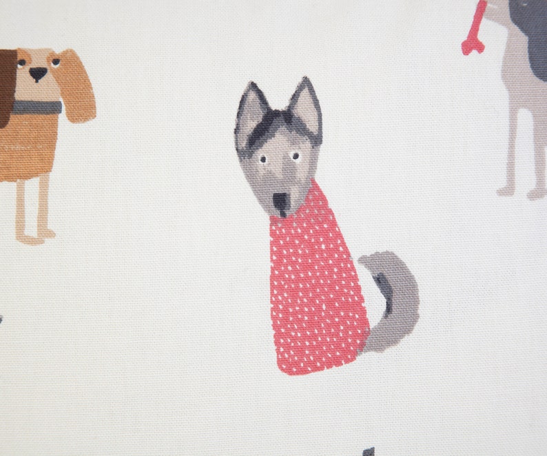 K&ouml;nnte beinhalten: Ein wei&szlig;er Stoff mit einem sich wiederholenden Muster aus Cartoon-Hunden. Ein Hund ist braun mit einem schwarzen Halsband, ein anderer ist grau mit einem roten Pullover und der dritte ist grau mit einem Knochen im Maul.