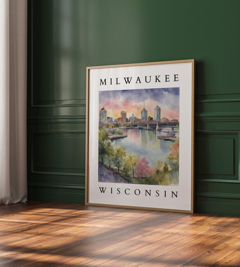 A large Milwaukee, Wisconsin watercolor print leaning against a rich green accent wall, with soft natural lighting highlighting the artwork.
