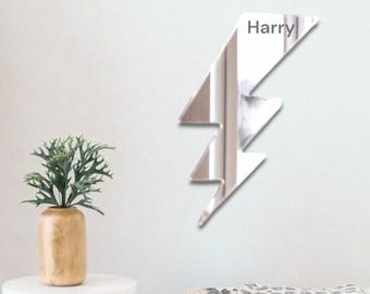 May include: A silver mirrored lightning bolt wall decor with the name "Harry" written on it.