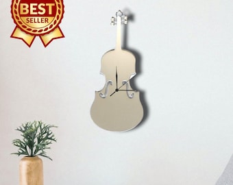 May include: A wall clock shaped like a violin with a reflective silver surface. The clock features a long neck, a curved body, and black hour and minute hands positioned in the center. The design is sleek and metallic, mounted on a plain wall.