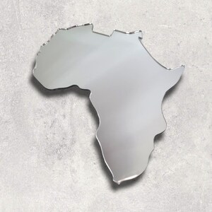 May include: A silver mirror shaped like the continent of Africa. The mirror is on a gray textured background.