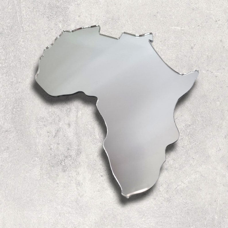 May include: A silver mirror shaped like the continent of Africa. The mirror is on a gray textured background.