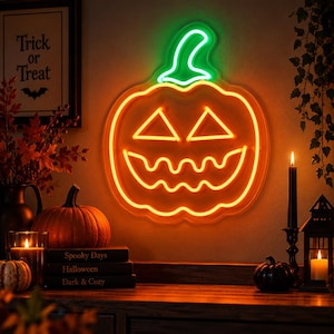 May include: A neon sign shaped like a jack-o'-lantern with a bright orange glowing pumpkin body and a green glowing stem. The pumpkin features two triangular eyes and a jagged, wavy mouth, all illuminated in a vibrant orange neon light.
