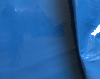 May include: A close-up of a smooth, shiny, blue surface. The surface is folded over on itself, creating a crease.