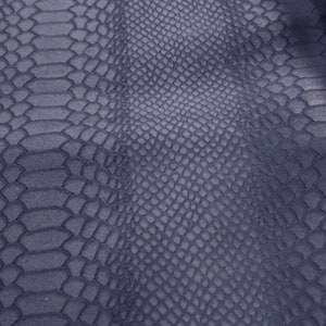 Peut inclure: Gros plan sur un tissu textur&eacute; gris fonc&eacute; avec un motif peau de serpent.