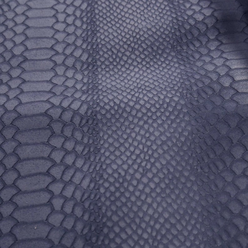 Peut inclure: Gros plan sur un tissu textur&eacute; gris fonc&eacute; avec un motif peau de serpent.