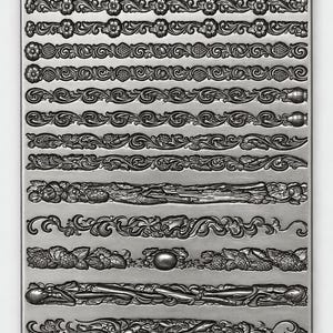 May include: A rectangular silver-toned metal mould featuring twelve distinct horizontal rows of embossed decorative patterns, including floral motifs, scrolling vines, geometric shapes, and fruit designs, all set against a smooth metallic surface.