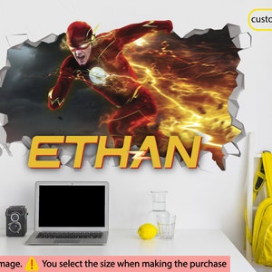 May include: A wall decal featuring the Flash, a superhero with red and yellow costume, breaking through a wall. The name "ETHAN" is written in yellow letters below the image.