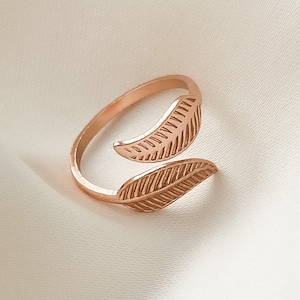 Op de afbeelding: Een ring van roségoud met twee bladeren. De ring is open en verstelbaar.