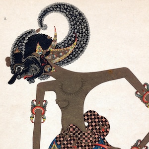 Op de afbeelding: Een illustratie van een Javaanse Wayang Kulit-pop. De pop heeft een zwart gezicht met ingewikkelde details, een grote, sierlijke hoofdtooi en is versierd met kleurrijke armbanden. De figuur is afgebeeld in een traditionele pose, met uitgestrekte armen.