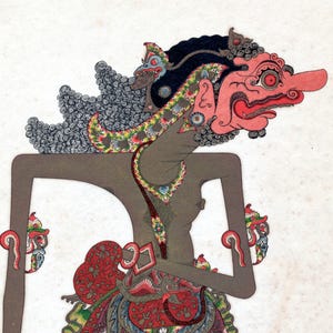 Op de afbeelding: Gedetailleerde illustratie van een traditionele Indonesische Wayang Kulit-pop. De pop heeft een rood gezicht met een lange neus, versierd met ingewikkelde details en levendige kleuren, waaronder zwart, grijs en rood. De pop staat tegen een witte achtergrond.