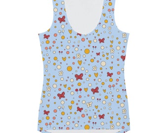 May include: Pale blue vest top featuring a repeating pattern of red polka-dot bows, yellow hearts, white flowers, and orange circles. The vest top has a scoop neck.