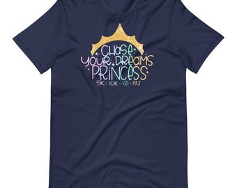 May include: A navy blue t-shirt featuring the phrase "CHASE YOUR DREAMS PRINCESS" in a colourful, whimsical font, with a gold crown graphic. The shirt also displays the numbers "5K • 10K • 13.1 • 19.3".