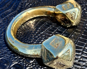 Pulsera tipo brazalete de latón macizo antiguo con diseño de guerrero tribal.