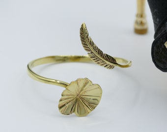 Bangle with lotus leaf & feather. Made by hand from melted cartridge cases. Made in Cambodia. Fairtrade