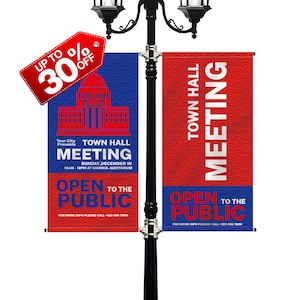 May include: Two red and blue banners hanging from a street lamp post. The banners advertise a Town Hall Meeting, open to the public, on Sunday, December 10th from 10am to 12pm at the Council Auditorium. The banners also include the text "Open to the Public" and a phone number for more information.