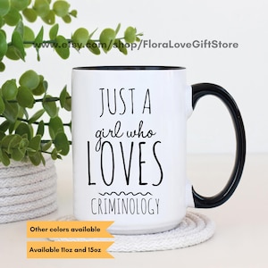 May include: White ceramic mug with a black rim and handle. The mug has black text that reads "Just a girl who LOVES Criminology".