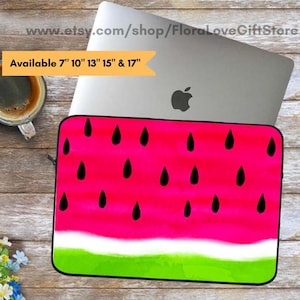 May include: A laptop sleeve with a watermelon design, featuring a bright pink background, green rind, and black seed details. Available in 7", 10", 13", 15" and 17" sizes. The sleeve is on a wooden surface with a laptop and a cup of coffee.