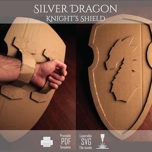 Op de afbeelding: Een kartonnen ridderschild met een uitgesneden drakenembleem aan de voorzijde en een handvat aan de achterzijde. Het schild is lichtbruin met een gegolfde textuur. De tekst op de afbeelding luidt SILVER DRAGON KNIGHT'S SHIELD, Printable PDF Template en Laserable SVG File Inside.