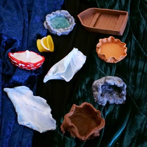 May include: A collection of small, handmade ceramic bowls and dishes in various colours and shapes. The bowls are perfect for holding small trinkets, jewellery, or other decorative items.
