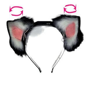 Op de afbeelding: Een zwart-witte kattenoren-hoofdband met roze binnenoren. De pluizige oren hebben een realistisch uiterlijk. De hoofdband is gemaakt van een flexibel materiaal voor een comfortabele pasvorm.
