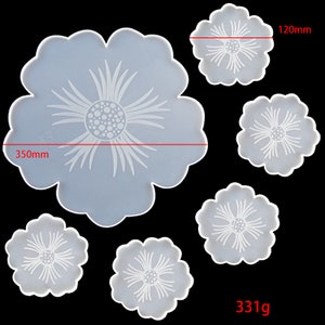 May include: Set of six silicone moulds in the shape of flowers. The largest mould is 350mm in diameter and the smallest is 120mm in diameter. The moulds are made of clear silicone and have a white floral design.