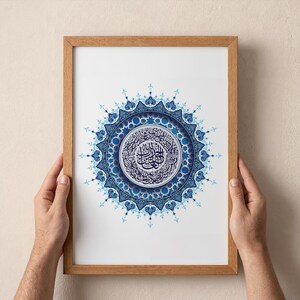 Affiche Sourate Al Fatiha en calligraphie arabe au centre d’un mandala islamique bleu raffiné. Présentée dans un cadre en bois naturel, cette décoration murale islamique apporte une atmosphère spirituelle, apaisante et élégante à votre intérieur. Idéale pour un salon moderne, une chambre ou un espace de prière, cette affiche coranique en téléchargement numérique est parfaite pour celles et ceux qui recherchent un art islamique minimaliste, harmonieux et profondément symbolique.