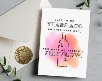 Può includere: Un biglietto di auguri di compleanno divertente con uno sfondo ad acquerello che presenta una bottiglia di vino rotta. Il biglietto recita "Pensa solo, anni fa, in questo stesso giorno, eri un disastro assoluto."