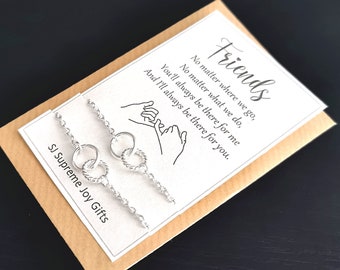 Peut inclure: Deux bracelets d'amitié en argent avec des anneaux entrelacés. La carte indique "Friends No matter where we go, No matter what we do, You'll always be there for me And I'll always be there for you."  SJ Supreme Joy Gifts