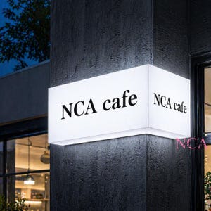 Puede incluir: Letrero rectangular blanco iluminado con el texto "NCA cafe" en letras negras. El letrero est&aacute; montado en una pared texturizada de color gris oscuro, con el nombre del caf&eacute; visible desde m&uacute;ltiples &aacute;ngulos.