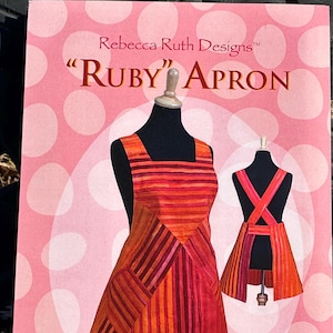 May include: A sewing pattern for a "RUBY" apron. The pattern is easy to make and comes in three sizes. The pattern is designed by Rebecca Anderson and the pattern number is RRD 309.