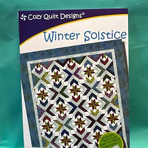 May include: A quilt pattern booklet titled "Winter Solstice" by Georgette Dell'Orco. The cover features a colorful quilt design with a blue background and a variety of geometric shapes. The pattern is for a strip club quilt using 2 1/2 inch strips.