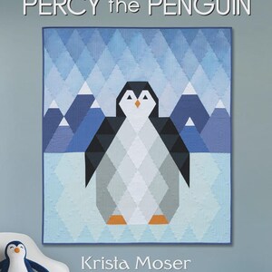 May include: A quilted wall hanging featuring a geometric penguin design. The penguin is black, white, and gray, set against a blue diamond pattern background with mountain shapes. The text "PERCY the PENGUIN" is at the top, and the lap size is 42" x 48".