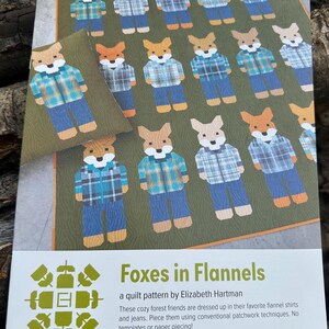 May include: A quilt pattern featuring a design of foxes wearing flannel shirts and jeans. The pattern is titled "Foxes in Flannels" and is by Elizabeth Hartman. The text also states that the pattern uses conventional patchwork techniques and does not require templates or paper piecing.