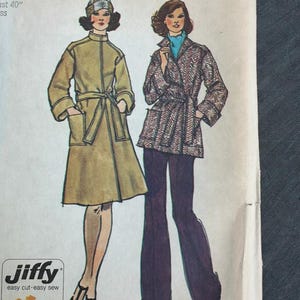 May include: A Simplicity sewing pattern envelope, number 5633, featuring illustrations of two outfits: a tan belted coat with a matching hat and a herringbone patterned jacket with a tie belt worn over dark trousers. Text includes Jiffy.