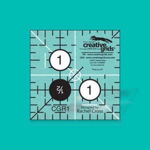 May include: A blue and white quilting ruler with a fox logo and the text "Creative Grids" and "Turn-a-Round". The ruler has a 3/4 inch circle and a 1 inch circle. The ruler is labeled "CGR1" and "Designed by Rachel Cross".