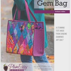 May include: A tote bag pattern titled Dancing Diamonds Gem Bag by Bethany Miller. The bag features a colorful, quilted diamond-patterned front and solid purple quilted sides. Dimensions are 15.5 inches wide by 13.5 inches high by 6.5 inches deep.