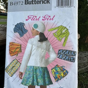 May include: A Butterick B4972 sewing pattern envelope for Girls Plus sizes 10 1/2 to 16 1/2. The cover features illustrations of a white jacket, a floral skirt, a blue top, a green jacket, plaid pants, and a patterned skirt with a white hat.