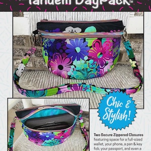 May include: A crescent-shaped crossbody bag featuring a vibrant floral pattern in shades of purple, pink, blue, and green. The bag includes an adjustable strap, two zippered closures, and an interior compartment shown holding a wallet and phone.