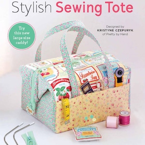 May include: A green and yellow sewing tote bag with a floral print and a zipper. The tote bag is filled with sewing supplies, including a pair of scissors, a spool of thread, and a measuring tape. The tote bag also includes wire frames and a hoop pull zipper.