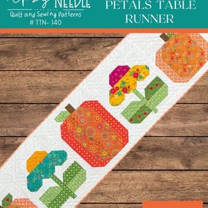 May include: A white table runner with a pumpkin and flower pattern. The runner features orange, red, green, and yellow geometric shapes. The text "PUMPKINS AND PETALS TABLE RUNNER" is at the top. The Tipsy Needle logo is in the upper left corner.