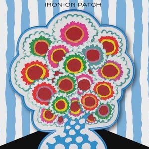 May include: An iron-on patch featuring a bouquet of colorful flowers. The flowers have red, pink, yellow, and green centers with white scalloped edges. The patch is outlined in blue, with the text "IRON-ON PATCH" at the top.