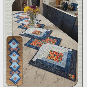 May include: A quilt pattern titled Sparkling Logs by Quilted Garden Designs by Jenice Belling. The image displays a table runner made of square blocks with a log cabin design, featuring orange poppy floral fabric and blue textured fabric.