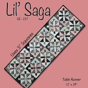 May include: A rectangular table runner with a geometric pattern in black, white, pink, and teal. The text "Lil' Saga" and "GE-237" are at the top. The table runner measures 13 inches by 39 inches.