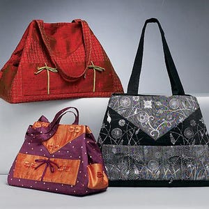 May include: Three tote bags with dual handles and front pockets featuring tie closures. One bag is solid red with a textured pattern, one is purple with orange accents and white dots, and one is black with a white floral and botanical print.