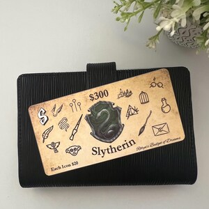 May include: A brown and gold card with a green and silver Slytherin crest and various Harry Potter themed icons. The card reads "$300" and "Each Icon $20". The card also reads "Slytherin" and "Robyn's Budget of Dreams".