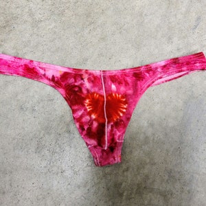 Könnte beinhalten: Rosa und rote Unterwäsche mit Batik-Muster und einer Herzform in der Mitte.